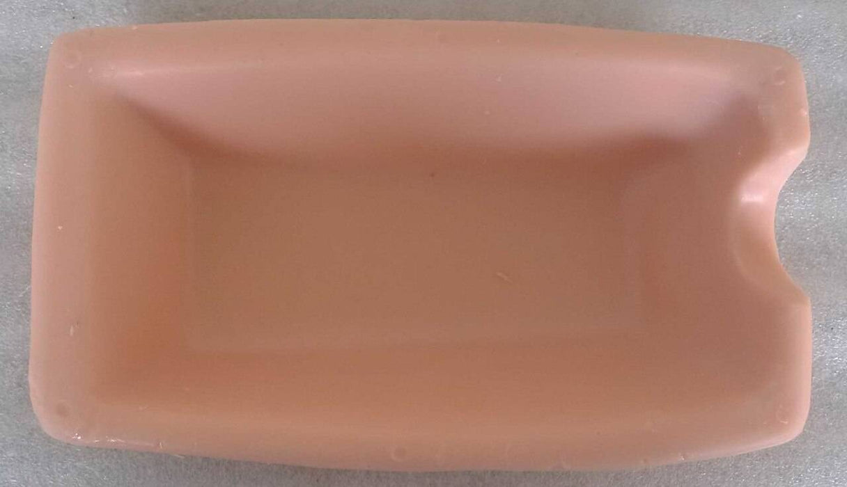 A light-pink rectangular tray sits on a white surface. It is shallow and has a slight indentation on one side.