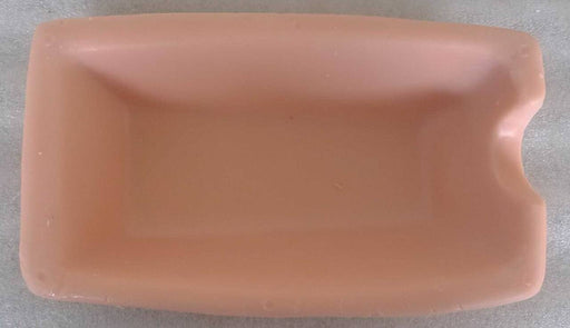A light-pink rectangular tray sits on a white surface. It is shallow and has a slight indentation on one side.