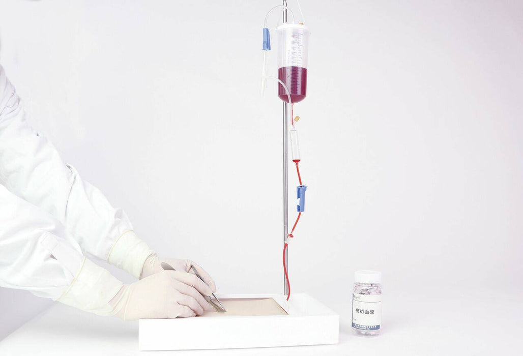 A blood bag hangs from a stand, undergoing a transfusion process; a gloved hand is near the tubing, in a sterile medical setting.