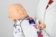 A lifelike baby doll is being held gently by a person wearing a white lab coat, in what appears to be a clinical setting.
