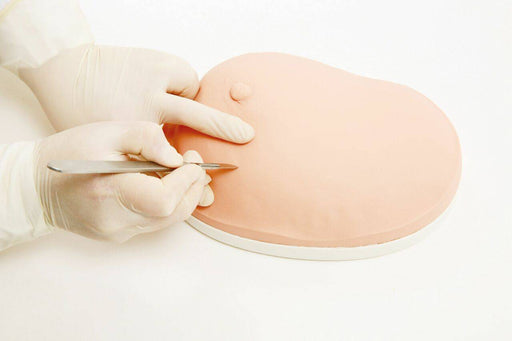 Gloved hands use a scalpel to incise a skin-toned training model on a white surface.