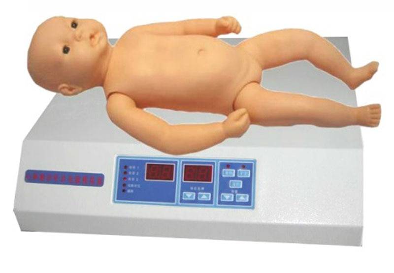 A plastic baby doll lies flat on its back on a white digital scale. The scale has a dark-colored display and button controls on the front.