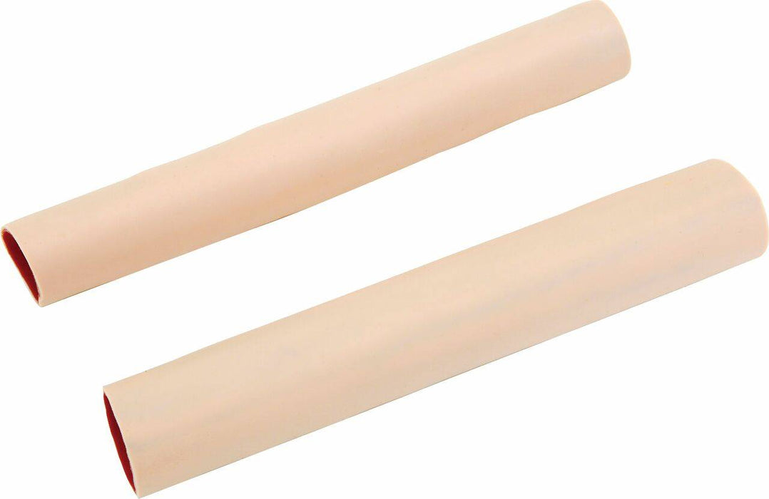 Two open-ended cylinders, with a tan exterior and red interior, rest diagonally against a white background.