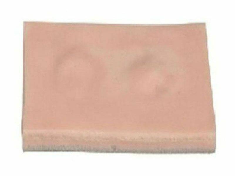 A pink, rectangular pad exhibits slight surface indentations. It is on a plain white background.