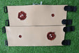 Two tan, simulated-skin panels, each showing simulated wounds, are fastened with black straps; they lie on artificial turf.
