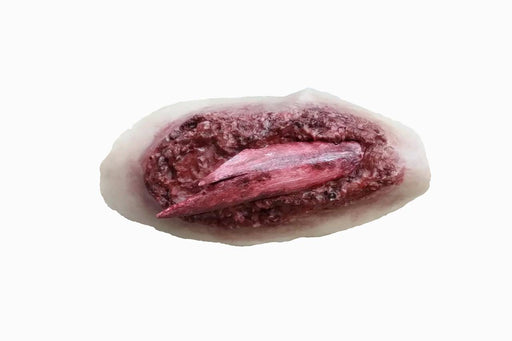 A simulated laceration, featuring a deep red wound with a protruding piece of flesh, rests on a pale background.