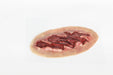 A simulated wound, appearing lacerated and bloody, rests on a plain white surface.