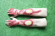 Two artificial arms, displaying simulated burns and blisters, rest on artificial turf.