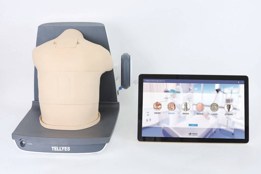 A medical training torso rests on a gray Tellyes base, next to a screen. The screen displays icons showing different organs and anatomy, in a sterile room.