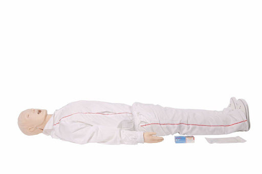 A medical dummy lies supine on a white surface. It is clothed in white surgical scrubs and wearing white sneakers. Next to it lies a box of “KY jelly”.