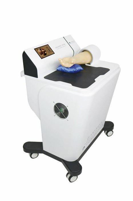 A medical device rests on wheels. A mannequin arm is positioned on a blue cushion atop the machine. The device has a small screen displaying an image.