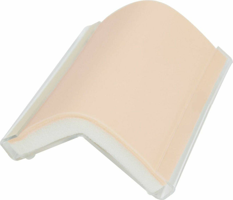 A flexible, skin-toned practice pad rests on a clear plastic frame. The pad is curved, suggesting use for practicing injection or incision techniques.