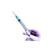 A syringe is being held by a gloved hand against a white background.