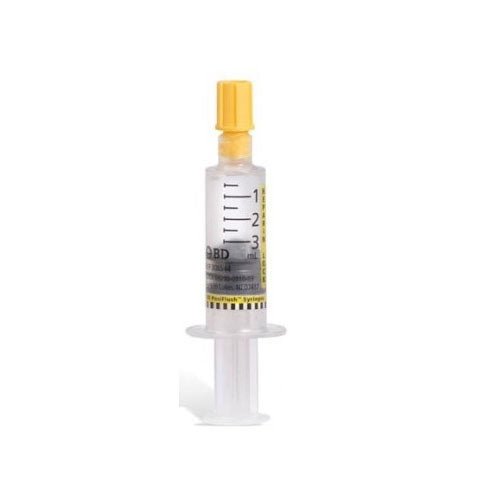A 3 mL BD Pedi-Flush syringe stands upright. It contains a clear liquid, and is marked with milliliter measurements.