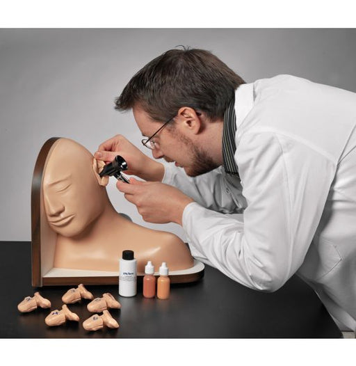 A doctor examines a medical model of a human ear with a magnifying glass; assorted small containers and ear models are on a wooden base nearby.