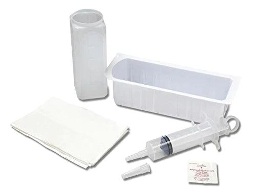 A medical syringe sits beside a small rectangular container, gauze pads, and other medical supplies; all are arranged on a plain white background.