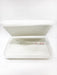 A blurry, white plastic container is stacked with its lid slightly ajar, sitting against a clean, bright, white backdrop.