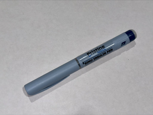 A gray Pristine Medical Simu Insulin Pen rests on a light gray surface.