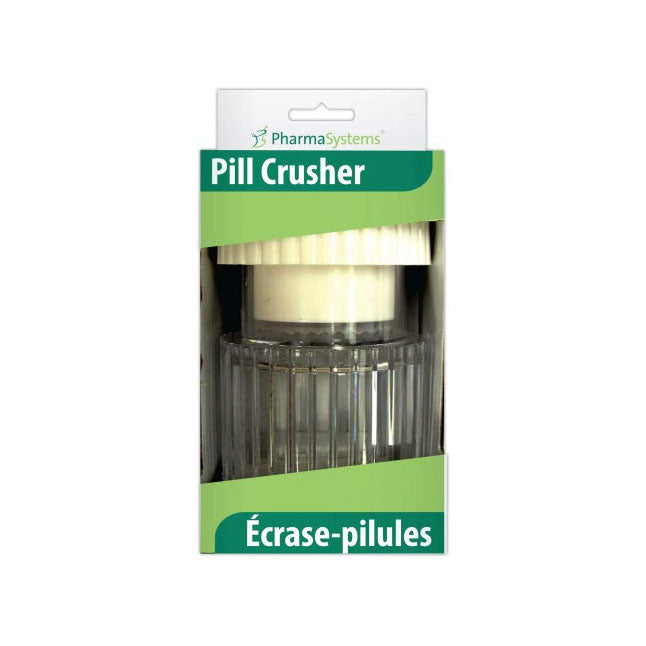 A pill crusher sits in its packaging. The package has green labeling with "PharmaSystems Pill Crusher Écrase-pilules" printed on it.