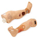 Two prosthetic legs lie side-by-side on a surface. One leg is slightly angled, showing both the calf and foot sections with simulated wounds. The other leg displays similar features.