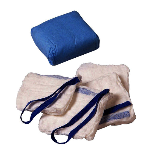 Off-white gauze squares with dark blue ties are stacked near a blue, square cloth.